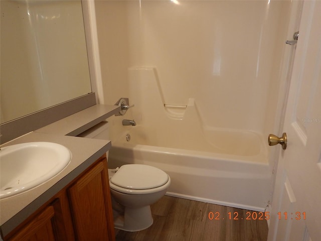 bathroom with toilet, bathtub / shower combination, wood finished floors, and vanity