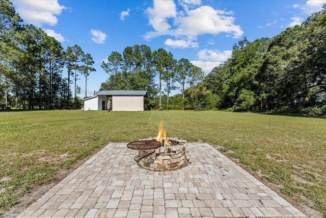 view of yard featuring an outdoor fire pit and a patio