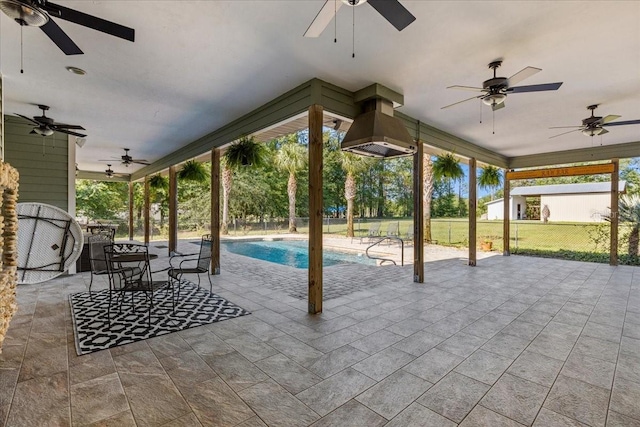 view of patio featuring outdoor dining area, fence, and an outdoor pool