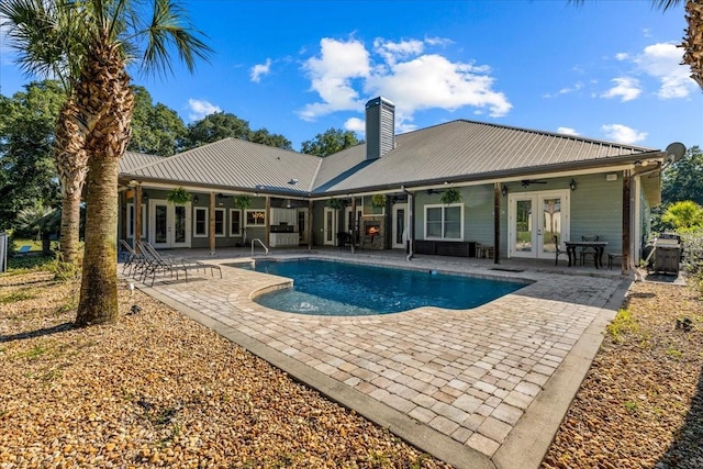 outdoor pool with french doors, a patio area, and a ceiling fan