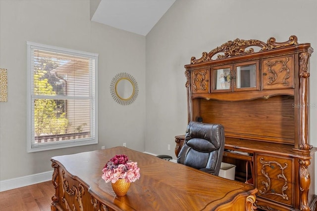 office area featuring lofted ceiling, wood finished floors, and baseboards