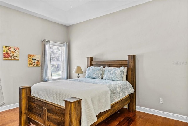 bedroom with baseboards and wood finished floors