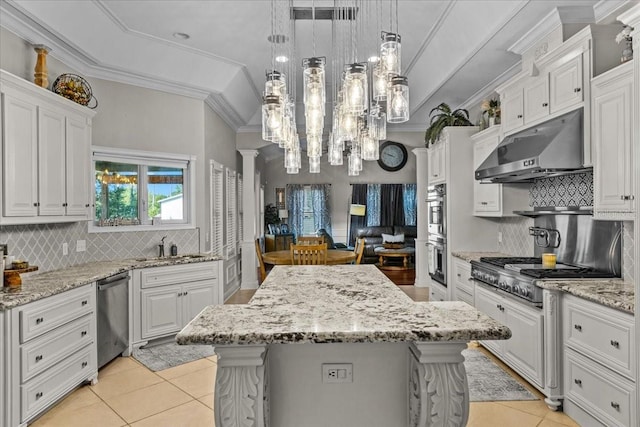 kitchen with pendant lighting, stainless steel appliances, ornamental molding, white cabinetry, and under cabinet range hood