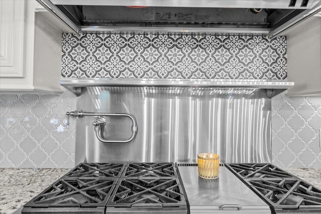 kitchen featuring light stone counters and white cabinets