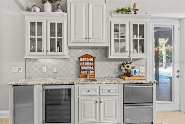 bar featuring light tile patterned floors, beverage cooler, backsplash, and refrigerator