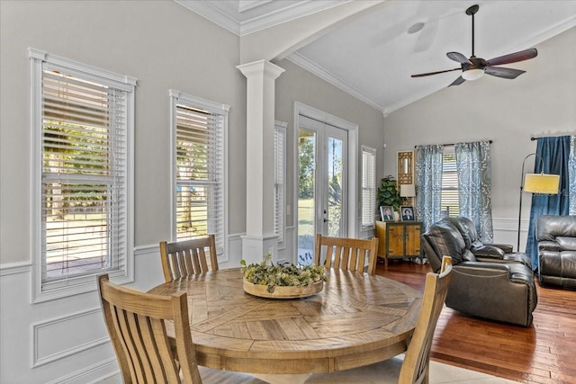 dining space with arched walkways, wood finished floors, decorative columns, and a healthy amount of sunlight