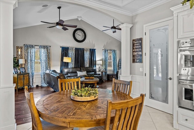 dining room featuring arched walkways, a ceiling fan, ornamental molding, wainscoting, and decorative columns