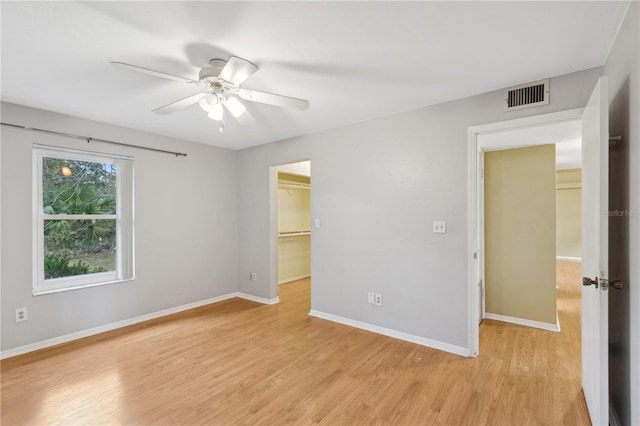 empty room with ceiling fan and light wood-type flooring