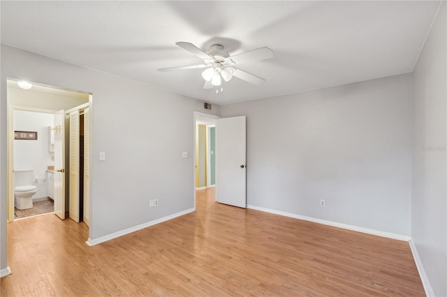 unfurnished bedroom with ensuite bathroom, ceiling fan, and light wood-type flooring