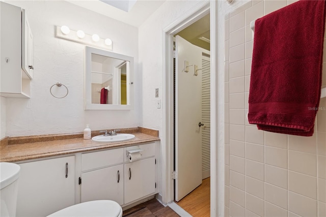 bathroom featuring wood-type flooring, vanity, and toilet