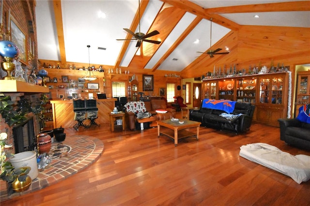 living room with ceiling fan, hardwood / wood-style flooring, high vaulted ceiling, and beamed ceiling