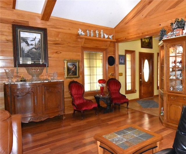 foyer featuring lofted ceiling, dark hardwood / wood-style flooring, and wood walls