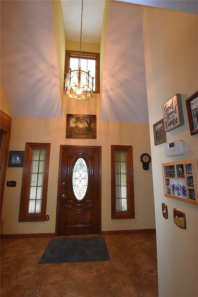 foyer entrance featuring a towering ceiling and a chandelier