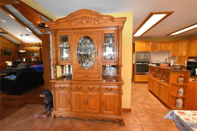 tiled foyer featuring lofted ceiling and ceiling fan