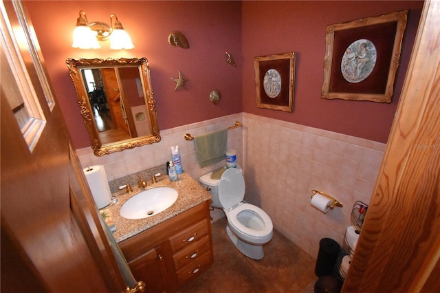 bathroom featuring tile walls, vanity, tile patterned floors, and toilet