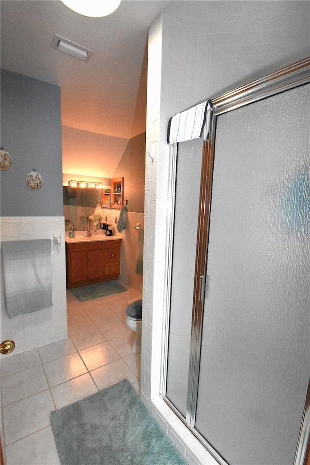 bathroom featuring tile walls, vanity, tile patterned floors, toilet, and walk in shower