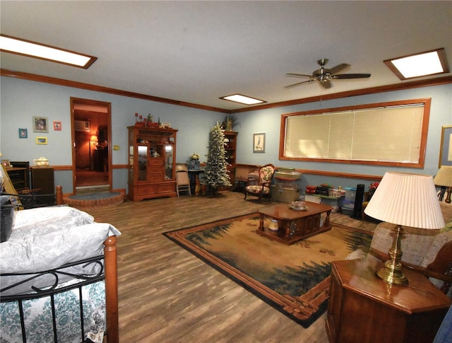 living room with ornamental molding, wood-type flooring, and ceiling fan