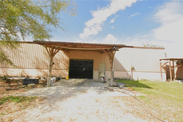 exterior space with a garage and an outbuilding