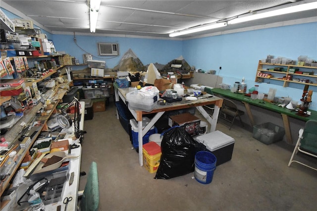 interior space featuring a wall mounted air conditioner, a workshop area, and concrete floors