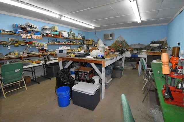 misc room featuring a wall mounted air conditioner, concrete flooring, and a workshop area