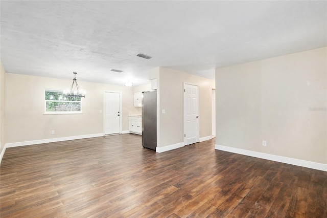 unfurnished room featuring dark hardwood / wood-style flooring and a chandelier