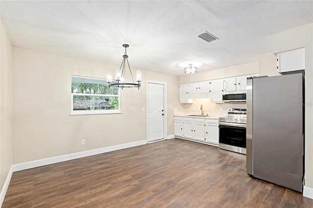 kitchen with dark hardwood / wood-style floors, pendant lighting, white cabinetry, sink, and stainless steel appliances