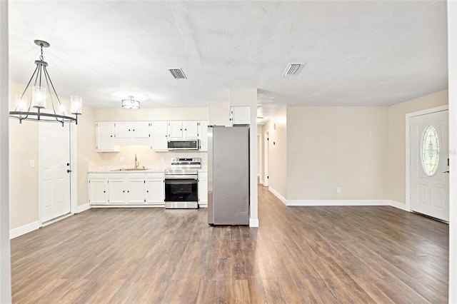 kitchen with dark hardwood / wood-style floors, white cabinetry, sink, hanging light fixtures, and stainless steel appliances