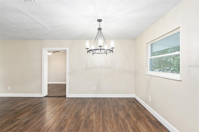 unfurnished dining area with dark wood-type flooring and an inviting chandelier
