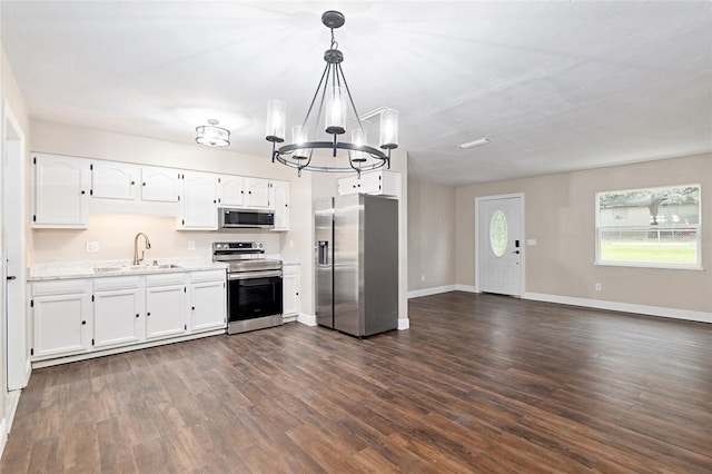 kitchen featuring white cabinetry, sink, decorative light fixtures, and appliances with stainless steel finishes