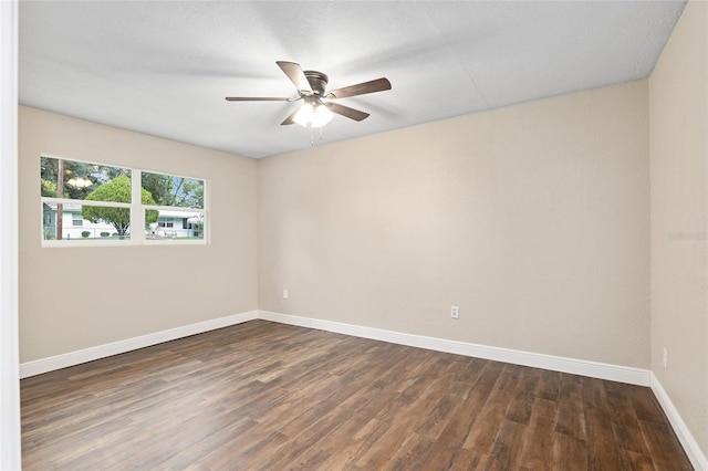 spare room with dark hardwood / wood-style floors and ceiling fan
