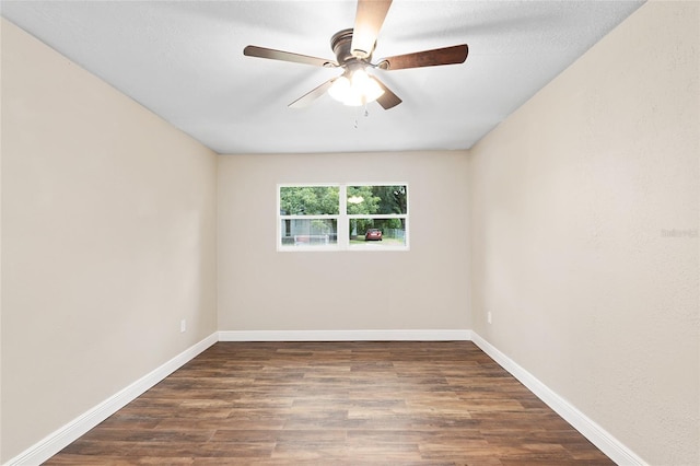 empty room with ceiling fan and dark hardwood / wood-style flooring