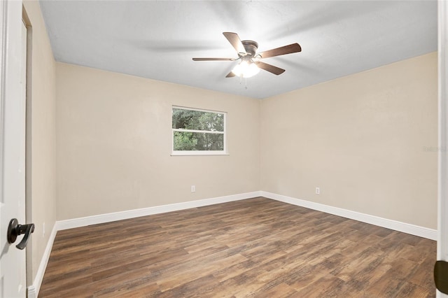 empty room with ceiling fan and dark hardwood / wood-style flooring
