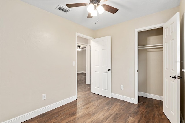 unfurnished bedroom featuring dark wood-type flooring, ceiling fan, and a closet