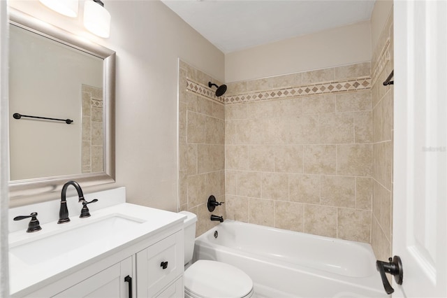 full bathroom with tiled shower / bath, vanity, and toilet