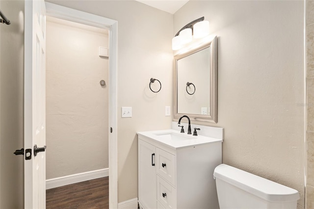 bathroom featuring vanity, hardwood / wood-style floors, and toilet