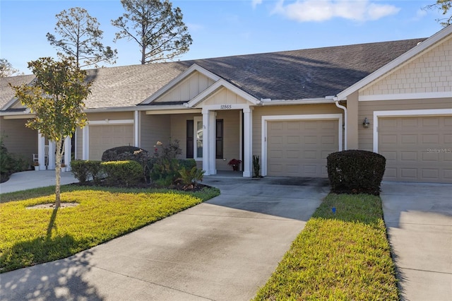 view of front of house with roof with shingles, a front lawn, board and batten siding, and concrete driveway