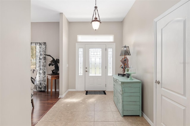 foyer entrance with light tile patterned flooring and baseboards