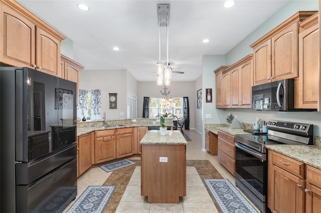 kitchen with light stone counters, appliances with stainless steel finishes, a kitchen island, a sink, and a peninsula