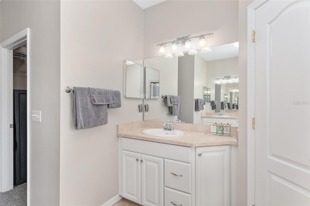 bathroom with a spacious closet and vanity