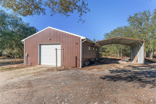 view of outbuilding with driveway, an outdoor structure, and a detached carport