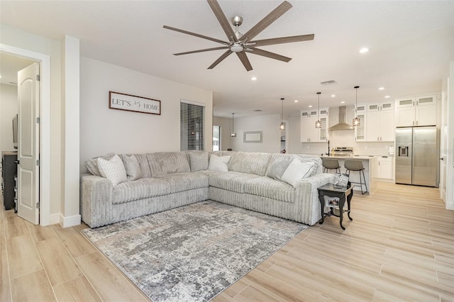 living room with ceiling fan and light wood-type flooring