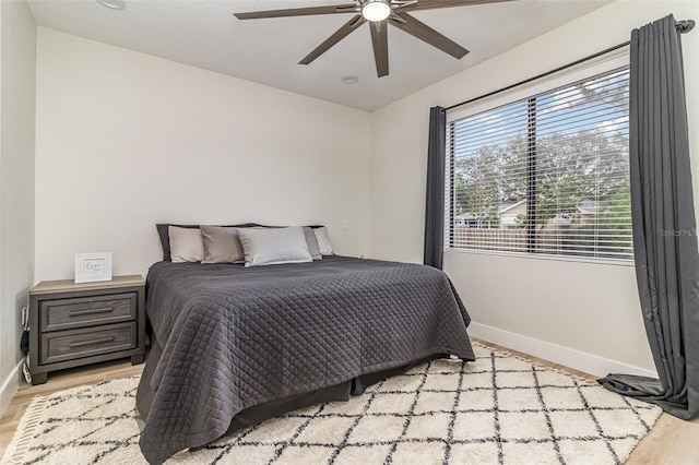 bedroom with light hardwood / wood-style floors and ceiling fan