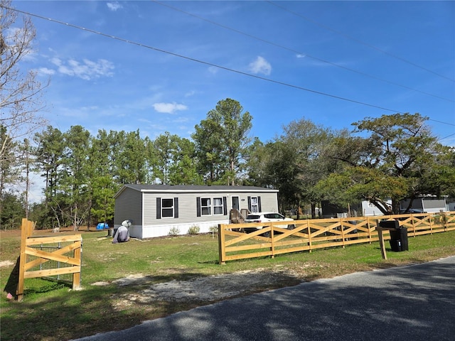 manufactured / mobile home with a fenced front yard and a front yard