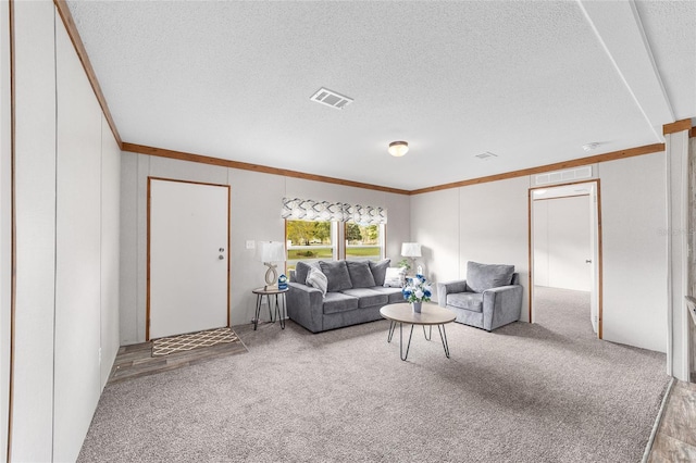 living area with ornamental molding, visible vents, light carpet, and a textured ceiling