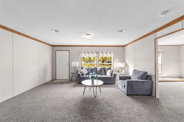 carpeted living room with a textured ceiling, ornamental molding, and visible vents