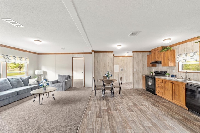 kitchen with black appliances, visible vents, light countertops, and open floor plan