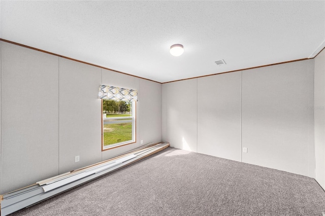 unfurnished room featuring a baseboard heating unit, carpet floors, a textured ceiling, and crown molding