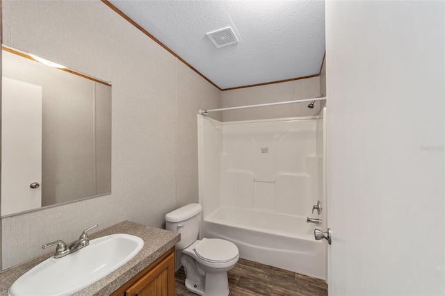 bathroom featuring shower / bath combination, toilet, vanity, a textured ceiling, and wood finished floors