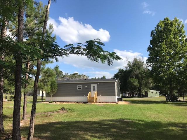 back of house featuring entry steps and a yard