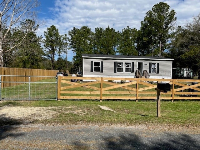 view of front of house featuring a fenced front yard, a gate, and a front lawn